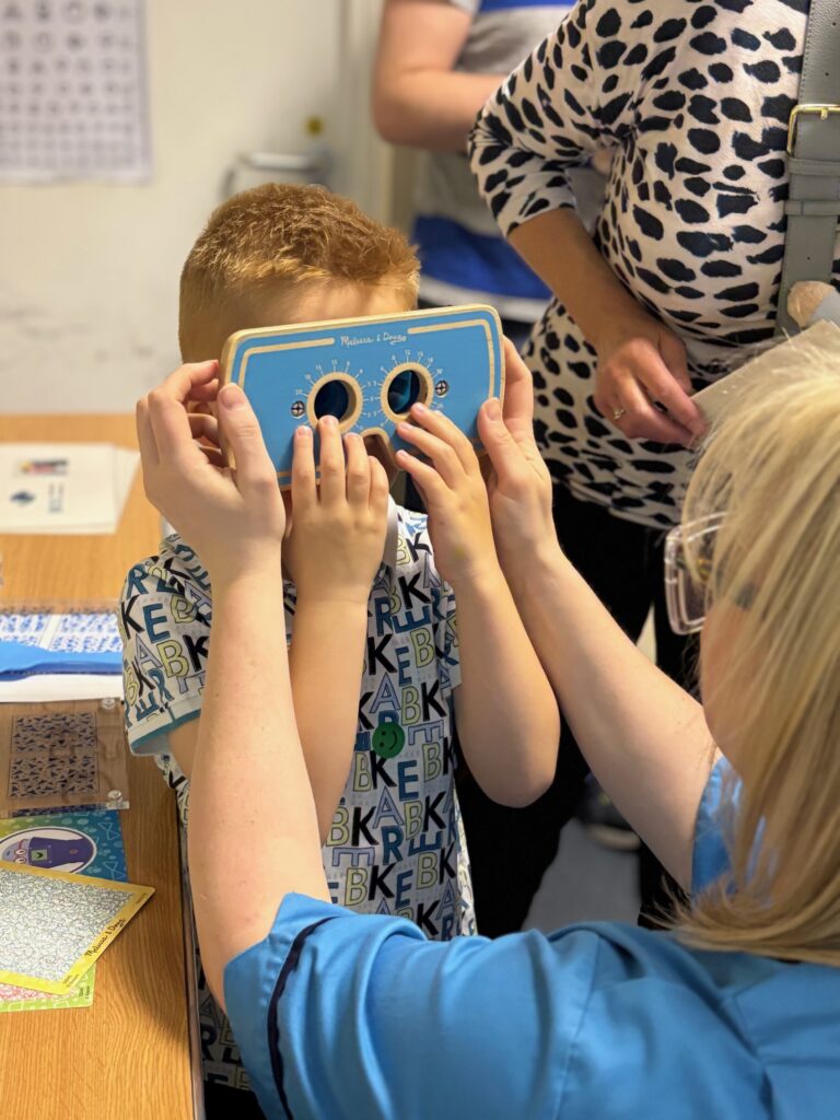 Child having an eye examine by a member of NHS staff