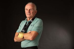 David standing in NHS Ayrshire & Arran work clothes wearing his winning Hyrox gold medals around his neck