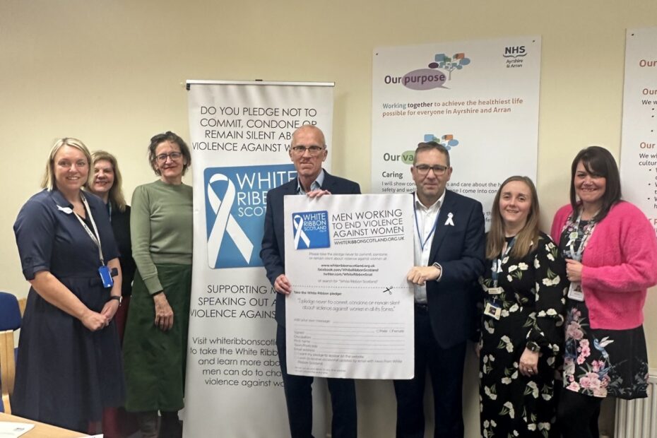 Senior Management team, Gordon James and Dr McGuffie standing holding the white ribbon pledge