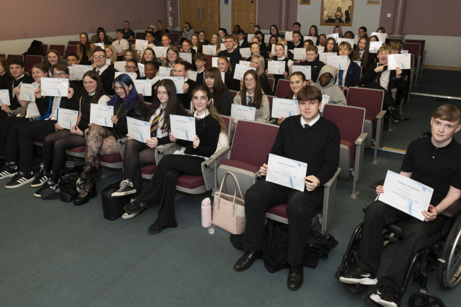 Image with senior school pupils in a lecture theatre holding certificates