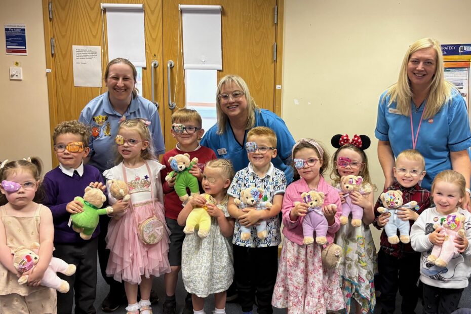 Group of children wearing eye patches standing with NHS staff behind them at the patch party event.